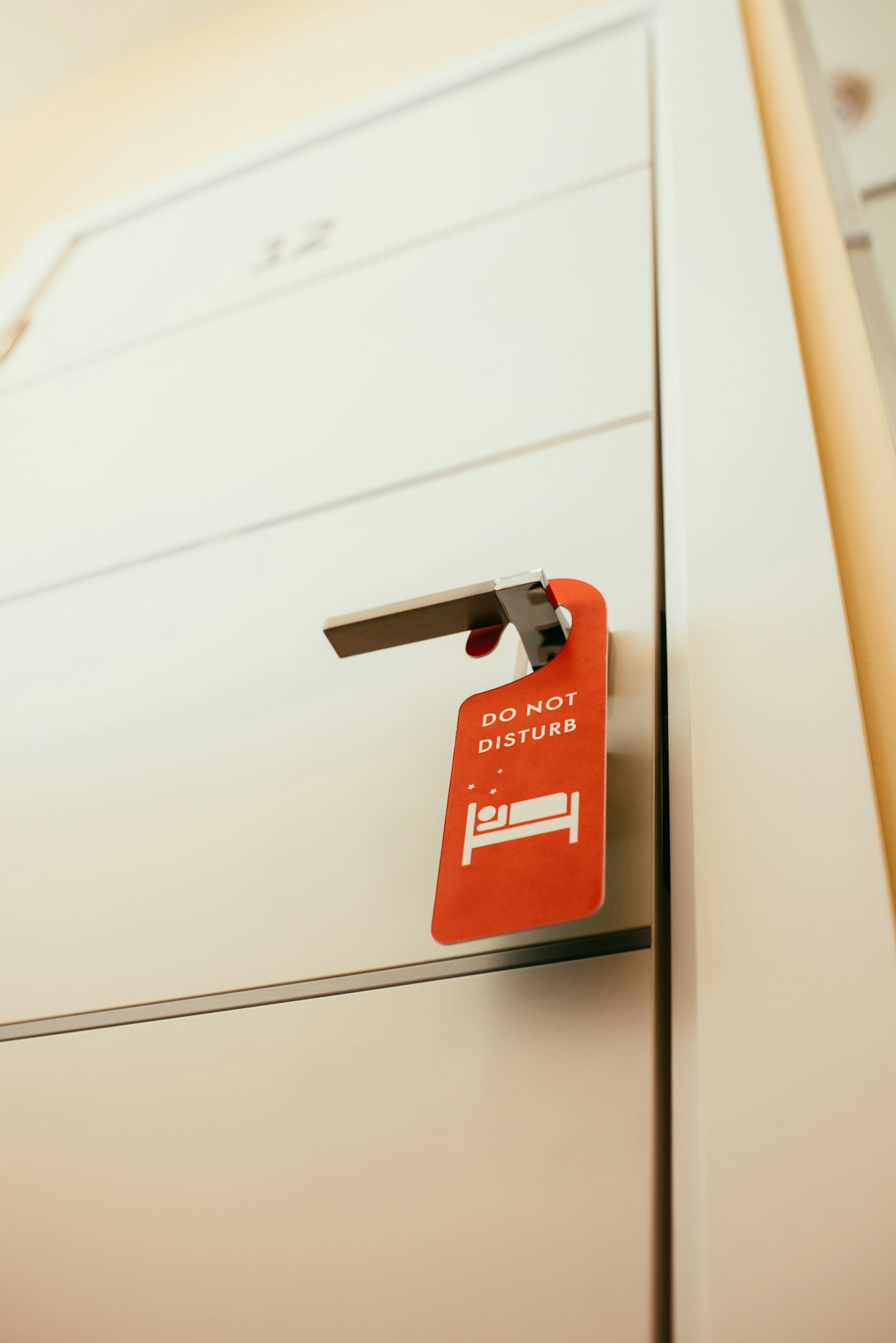 red symbol with 'do not disturb' lettering on door handle in hotel